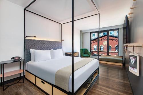 a hotel room with a bed and a window at Moxy NYC East Village in New York