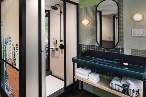 ニューヨークにあるMoxy NYC East Villageのバスルーム(青いシンク、鏡付)