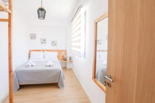 a small bedroom with a bed and a mirror at Village View Apartments in Himare