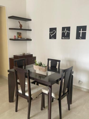 a black dining room table and chairs with a plant on it at Beachfront Condo Large Apartament in Rio de Janeiro