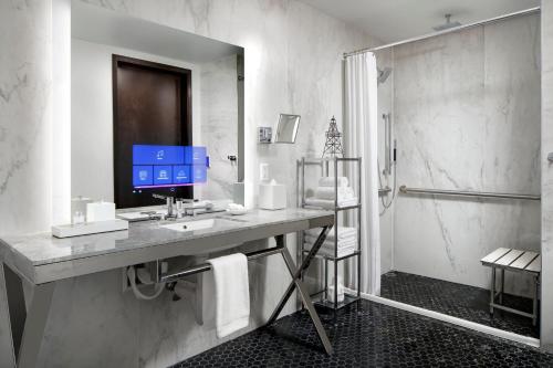 a bathroom with a sink and a shower at The Sinclair, Autograph Collection in Fort Worth