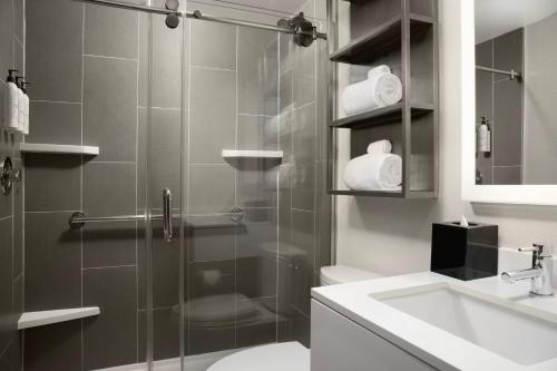 a bathroom with a shower and a toilet and a sink at TownePlace Suites by Marriott New York Manhattan/Times Square in New York
