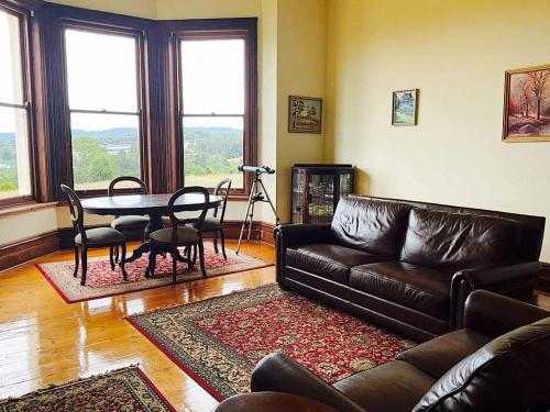 a living room with a leather couch and a table at Kimbell Hill Yarra Valley in Wandin East