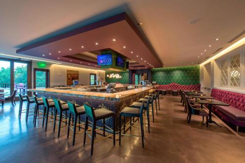 a bar in a restaurant with chairs and tables at Grand Bohemian Mountain Brook, Autograph Collection in Birmingham