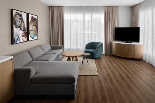 a living room with a couch and a television at The Westin Atlanta Gwinnett in Duluth