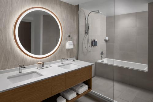 a bathroom with two sinks and a mirror and a tub at The Westin Atlanta Gwinnett in Duluth