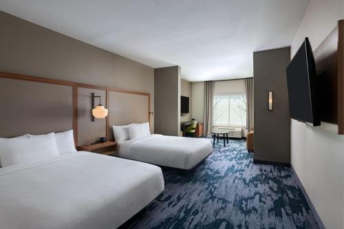 a hotel room with two beds and a flat screen tv at Fairfield by Marriott Inn & Suites Austin Georgetown in Georgetown