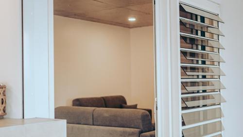 a living room with a couch and a book shelf at Pension Irivai, appartement UO UO 3 chambres vue mer in Uturoa