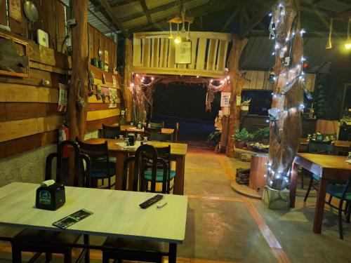 un restaurante con mesas y sillas en una habitación en Guapote Lodge en Tigra