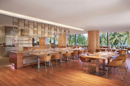 a restaurant with wooden tables and chairs and windows at Sheraton Nha Trang Hotel & Spa in Nha Trang