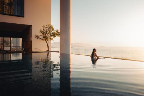 a woman sitting in the water in a swimming pool at Sheraton Nha Trang Hotel & Spa in Nha Trang