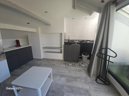 une pièce avec un banc blanc et une cuisine dans l'établissement Appart 3 chambres avec terrasse 18m - 8 pers - 1 place de parking, à Marseille