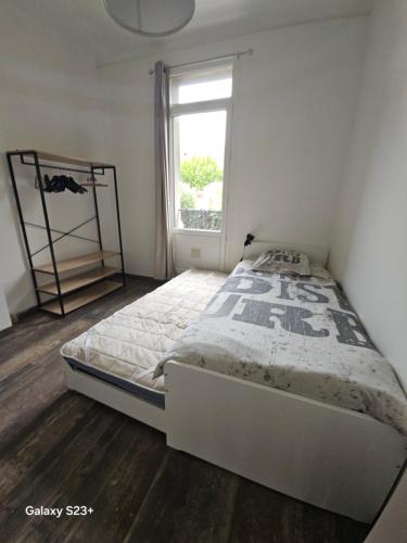 une chambre avec un lit et une fenêtre dans l'établissement Appart 3 chambres avec terrasse 18m - 8 pers - 1 place de parking, à Marseille