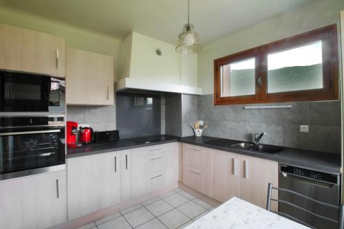 une cuisine avec des armoires blanches et des comptoirs noirs dans l'établissement Charming house with great views, à Brison-Saint-Innocent