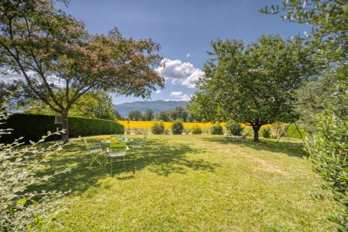 un jardin avec une table, des chaises et des arbres dans l'établissement Large family home 14 p, à Grésy-sur-Aix