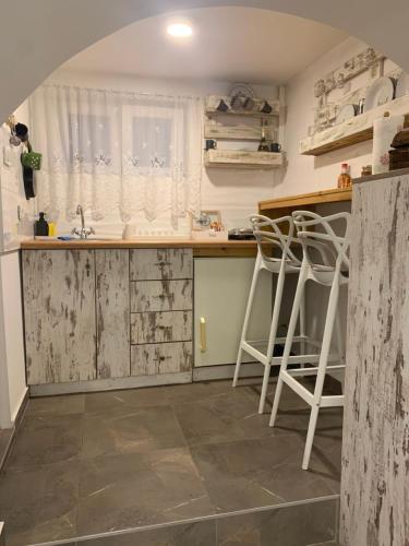 a kitchen with a sink and a counter with stools at Apartman Nina BANOVO BRDO in Belgrade
