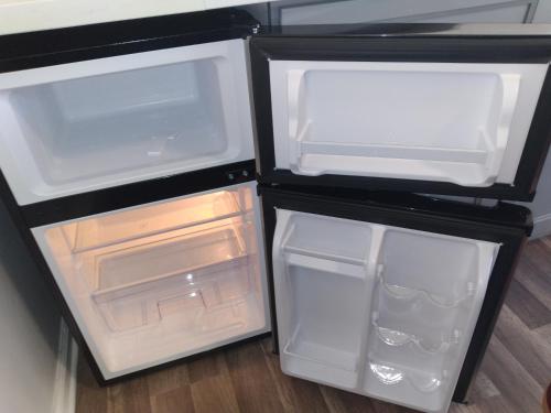 Un refrigerador vacío con la puerta abierta en una cocina. en LA Love Home, en Los Ángeles