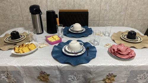 a table with a white table cloth with food on it at Hostel Anprado 1 in Guarulhos