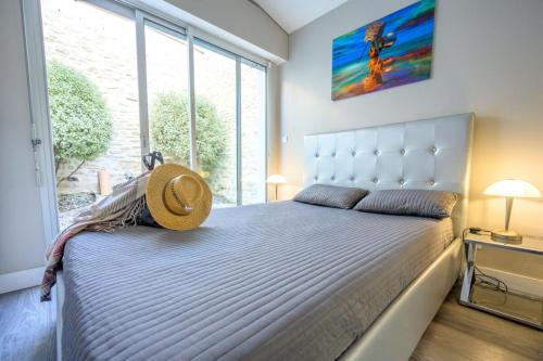 サン・マルタン・ド・レにあるLa Maisonnette Du Closのベッドルーム1室(大型ベッド1台、帽子付)