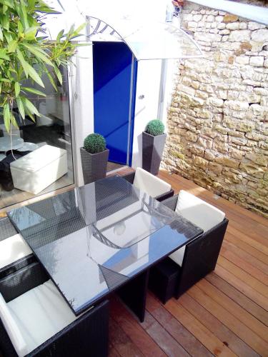 une table et des chaises en verre sur la terrasse dans l'établissement La Maisonnette Du Clos, à Saint-Martin-de-Ré