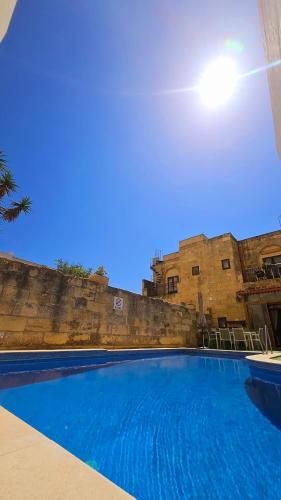 a large blue swimming pool in front of a building at Traditional Farmhouse Central Gozo in Xagħra