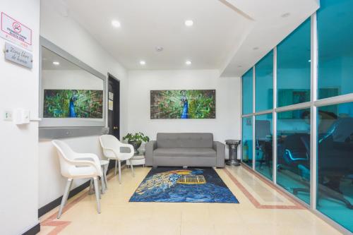 a living room with a couch and a table and chairs at Hotel Estadio Real in Medellín