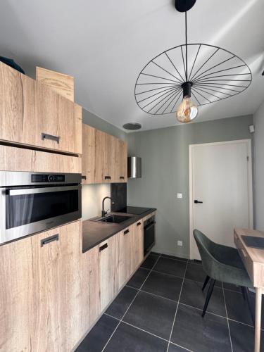 une cuisine avec des armoires en bois, un évier et une table dans l'établissement Atelier - Gare Saint Jean, à Bordeaux