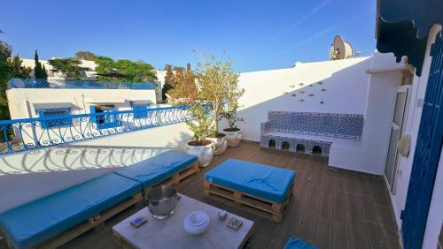 a balcony with blue benches and a table at Horizon Bleu - Sidi Bou Saïd in Sidi Bou Saïd