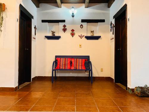 a bench in a room with a wall with some decorations at Hotel Ocho Barrios in San Cristóbal de Las Casas