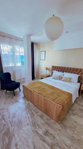 a large bedroom with a large bed and a chair at Horizon Bleu - Sidi Bou Saïd in Sidi Bou Saïd