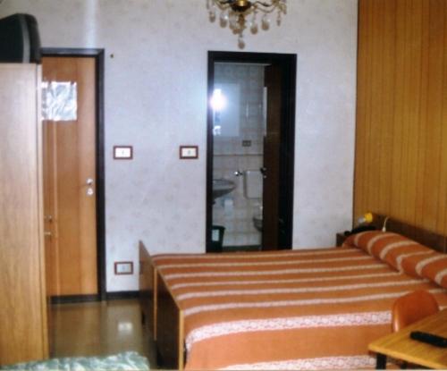 Habitación con cama, sofá y puerta en Dufour Hotel, en Châtillon