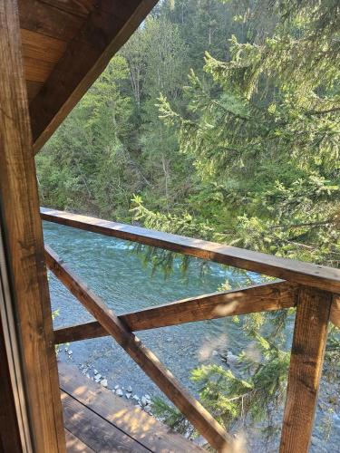 a view of a river from the porch of a cabin at 4 Mountains Hotel in Bystrets