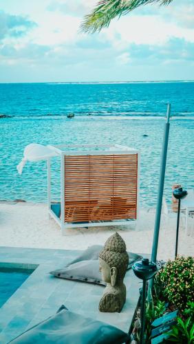 a statue sitting on a table next to the ocean at Pension Irivai appartement "Uparu" 1 chambre bord de mer in Uturoa