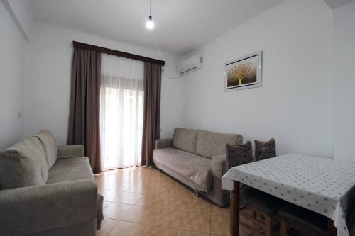 a living room with a couch and a table at Garden Vila Ermali in Ksamil