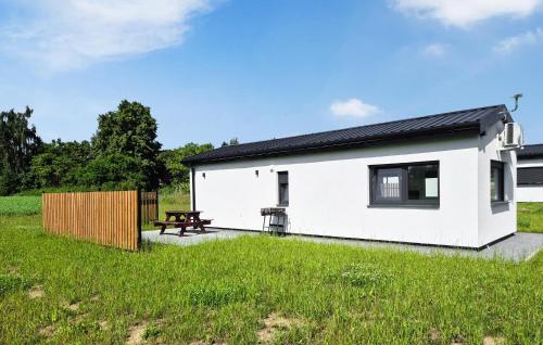 ein weißes Haus mit einem Picknicktisch auf einem Feld in der Unterkunft 1 Bedroom Beautiful Home In Bedzino in Będzino