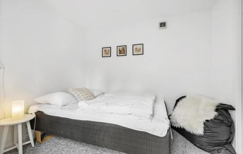 a bed in a room with a white wall at Nice Home In Store Fuglede With Wifi in Store Fuglede