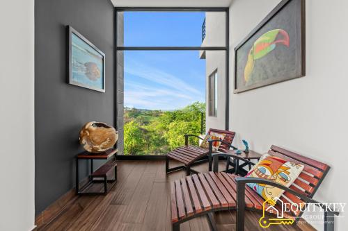 a balcony with a bench and a large window at Casa Luna Amarillo - Your Pacific Escape! in Playa Hermosa
