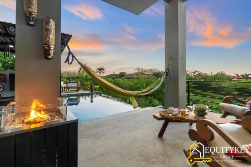 a living room with a fireplace and a hammock at Casa Luna Amarillo - Your Pacific Escape! in Playa Hermosa