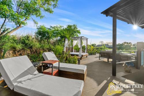 a patio with white furniture and a gazebo at Casa Luna Amarillo - Your Pacific Escape! in Playa Hermosa