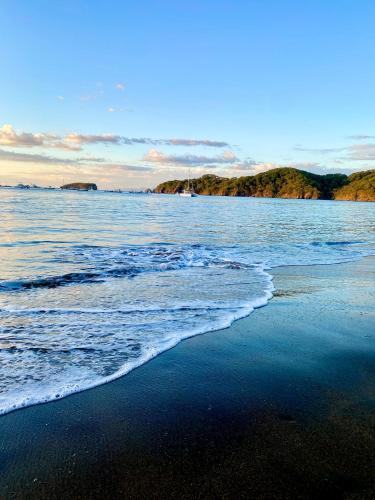 a beach with the ocean and a boat in the water at Casa Luna Amarillo - Your Pacific Escape! in Playa Hermosa