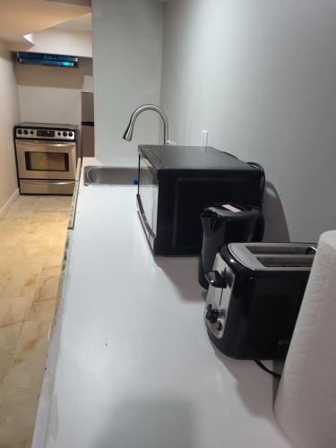 a kitchen with a counter with a sink and a toaster at Cozy room basement with separate entrance in Brampton
