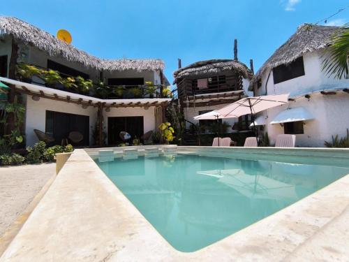 a swimming pool in front of a house at Arte Sano Hotel Only Adults - Near Beach in Holbox Island