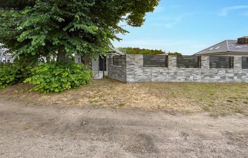 a stone fence in front of a house at Beautiful Home In Drogoradz With Kitchen in Drogoradz