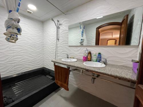 a bathroom with two sinks and a mirror at Villa plage tiguert résidence les méridiennes in Agadir
