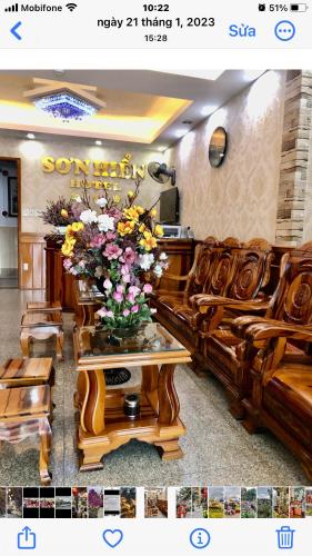 a room with a couch and a vase of flowers on a table at Khách Sạn Sơn Hiển in Cam Lâm
