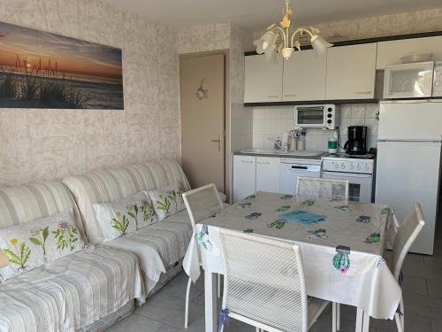 - une cuisine et une salle à manger avec une table et un canapé dans l'établissement Coquet Appartement T2, Balcon Sud, Parking Privé, 400m de la Plage - Fort-Mahon-Plage - FR-1-482-135, à Fort-Mahon-Plage