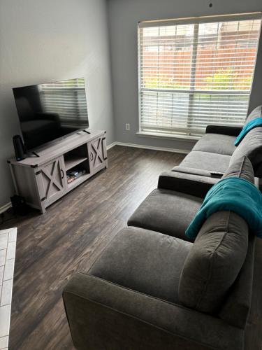 a living room with two couches and a flat screen tv at Hosting Nightly Nestings in Irving