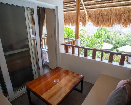 a living room with a wooden table and a balcony at Bathala Resort in Panglao