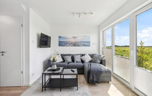 a living room with a couch and a large window at Stunning Home In Tossens With Sauna in Stick