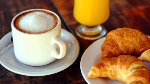 een kopje koffie en croissants op een tafel bij Nelly's Apartment in Buenos Aires